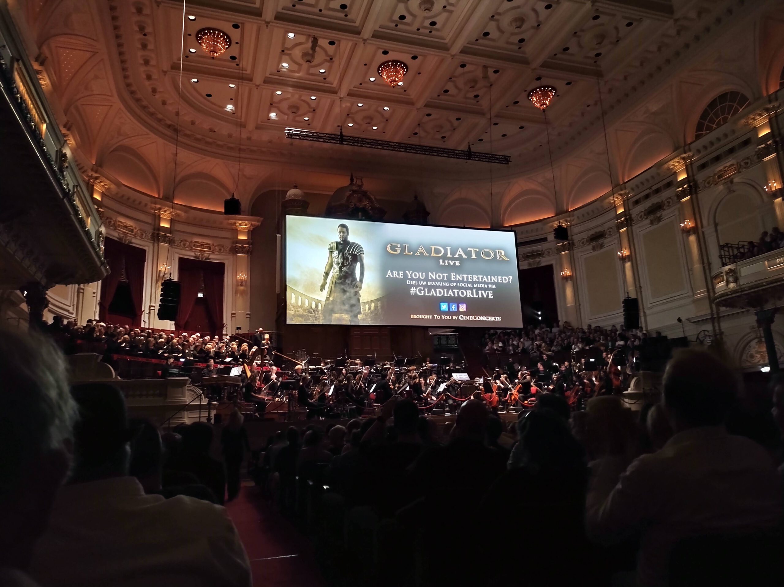 De film Gladiator op een groot scherm in het Concertgebouw Amsterdam met daaronder een orkest, koor en het publiek.